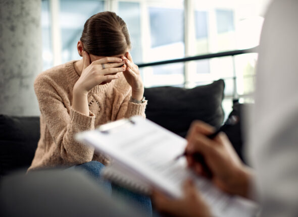 Depressed woman having psychotherapy session at doctor's office.
