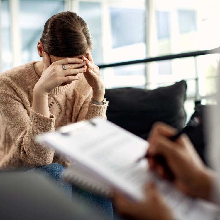 Depressed woman having psychotherapy session at doctor's office.